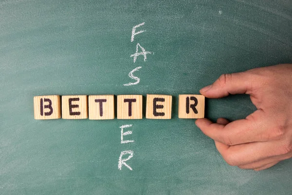 Concept meilleur et plus rapide. Texte des lettres de l'alphabet en bois sur un tableau à craie verte — Photo