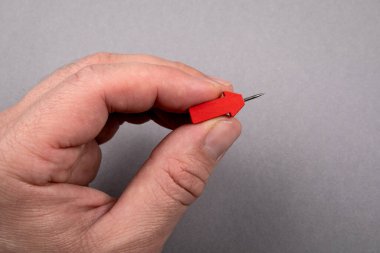 Bir adamın elinde kırmızı ok iğnesi. Gri arkaplan