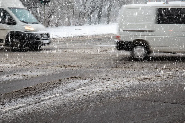 Traffic in the city. Snowfall, dirty roads and slippery — Stock Photo, Image