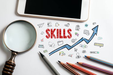 SKILLS kavramı. Beyaz arka planda büyüteç, cep telefonu ve renkli kalemler.