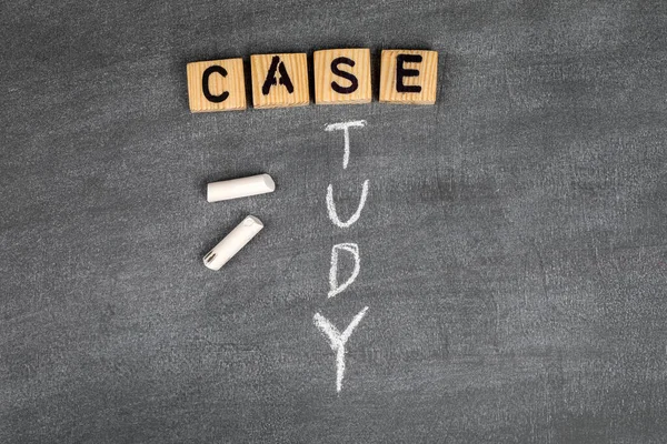 Case Study concept. Wooden alphabet letters on a gray chalk board