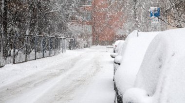 Karla kaplı park edilmiş arabalar, kar fırtınası. Kaygan ve tehlikeli.
