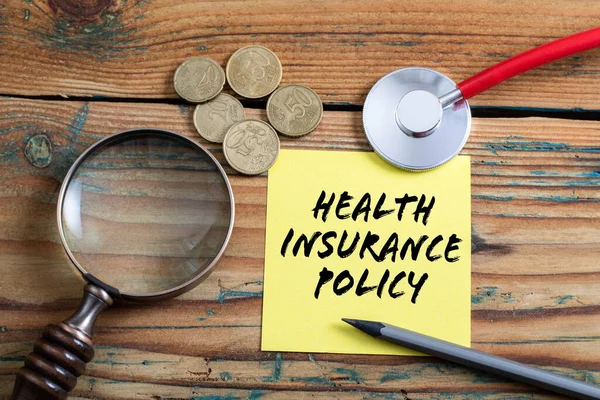 Health Insurance Policy. Red doctors stethoscope on a wooden table