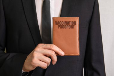 Vaccination Passport. Businessman showing passport covers. Travel concept
