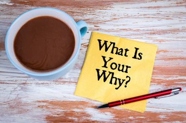 What Is Your Why. Yellow napkin and coffee mug on a wooden table