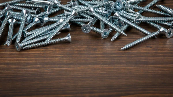 Tornillos galvanizados sobre fondo de madera. Construcción y reparación — Foto de Stock