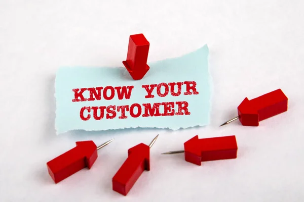 KNOW YOUR CUSTOMER. Note sheet and red arrows on white paper