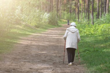 Retirement. Nordic walking in the forest or park. Healthy lifestyle
