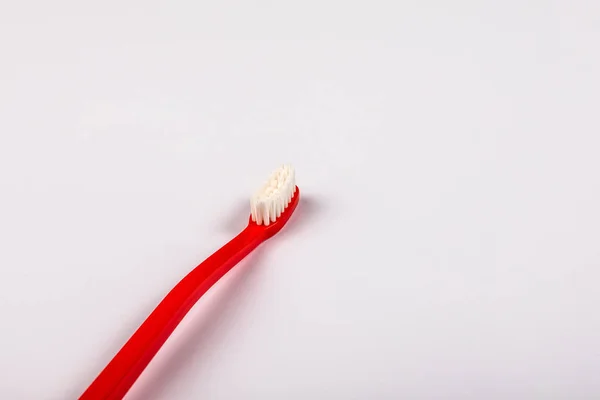 Red plastic toothbrush on a white background. Copy space — 스톡 사진