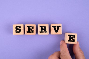 Hizmet. Mor zemin üzerinde yazı olan tahta küpler