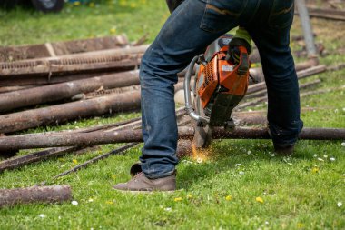 Dairesel testereli bir işçi metal boruları ve hurdaları testereyle keser. Kıvılcım ve ateş