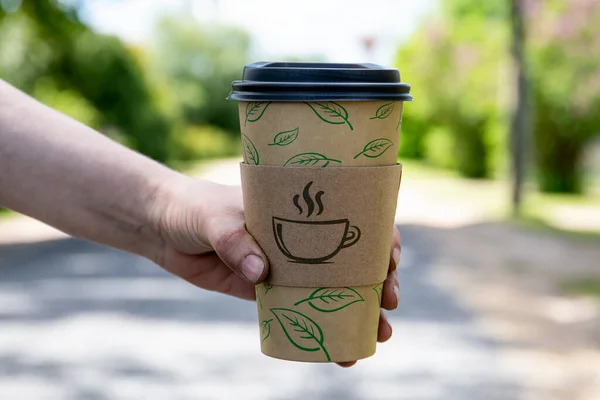 Kaffeebecher aus Papier in einer Frauenhand. Sonniger Tag — Stockfoto