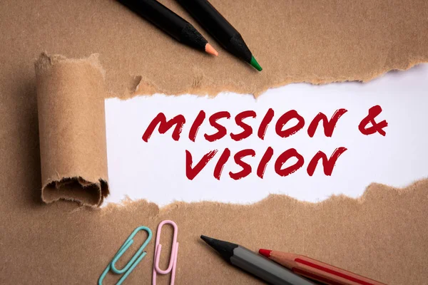 Mission and vision concept. Cardboard paper and pencils on a white background