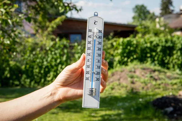 女性の手で白い温度計。極端な暑い天気 — ストック写真