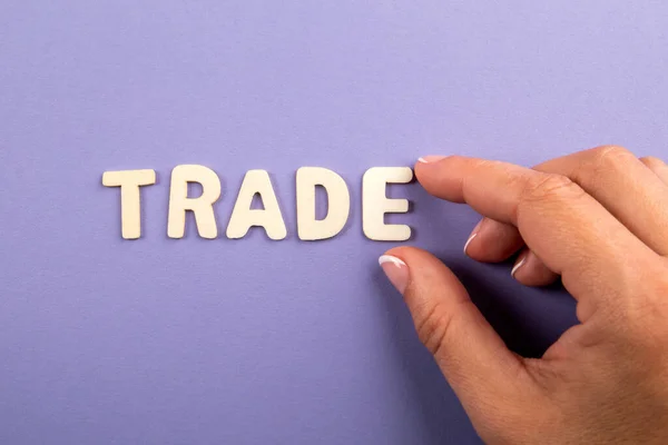 貿易だ。紫色の背景に白い文字と女性の手 — ストック写真
