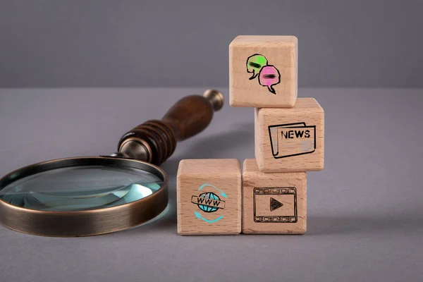 Social Media and Content Concept. Magnifying glass and wooden blocks on a gray background