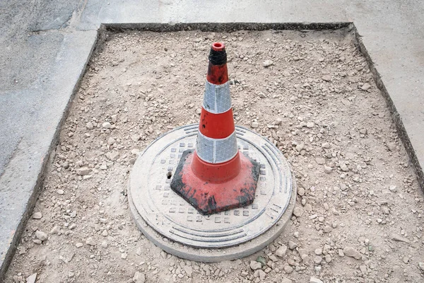 Warning cone with reflectors. Asphalt road repair and sewerage well — Stock Photo, Image