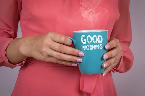 GUTES MORGEN. Frau in rosa Kleid mit Kaffeebecher in der Hand — Stockfoto