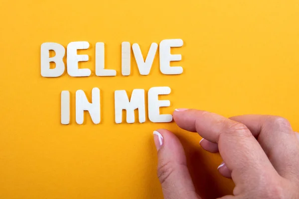 Geloof in mij. Witte houten letters met tekst op een gele achtergrond — Stockfoto
