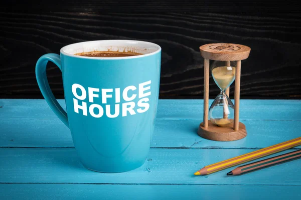 Bürozeiten. Kaffeebecher, Sanduhr und Bleistifte auf dem Schreibtisch — Stockfoto