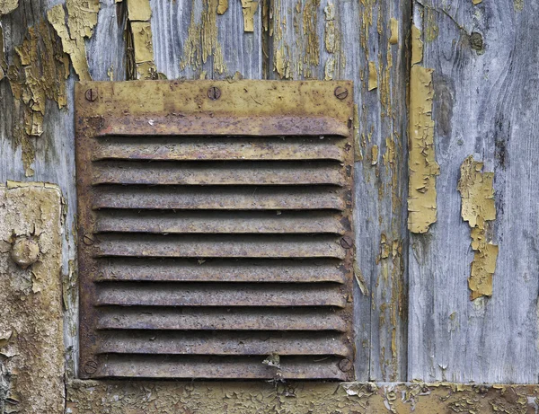 Corroded ventilation hatch on the wooden background with peeled — Stock Photo, Image