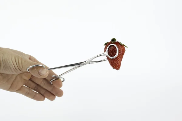 Χειρουργικά εργαλεία και κόκκινη φράουλα σε λευκό φόντο — Φωτογραφία Αρχείου