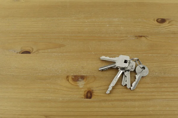 Μάτσο διαφορετικά κλειδιά σε ξύλινο τραπέζι — Φωτογραφία Αρχείου