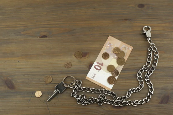 Llaves de la casa y pequeño cambio en la mesa de madera — Foto de Stock