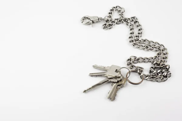 Bando de chaves de porta com corrente isolada no fundo branco — Fotografia de Stock