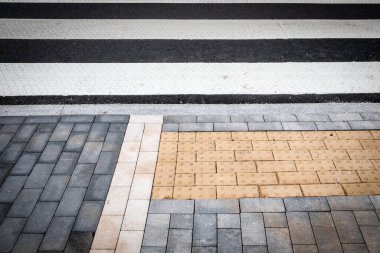 Beyaz ve siyah yol şeritli modern yaya geçidini kapatın ve kentsel kaldırımda görme engelli insanlar için dokunsal asfalt döşeme yapın. Güvenliğe erişim ve şehir sokak tasarımı.