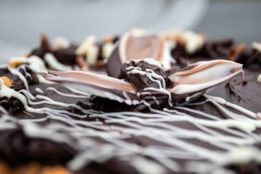 Detaylı krem süslemeli ve sanatsal kaplamalı bir çikolatalı pasta, dokuma, tatlılık ve tatlı zarafeti gösteriyor..