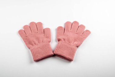 Beyaz arka planda bir çift pembe yün eldiven. Sıcaklık, konfor ve rahat kış kıyafetleri gerekli..