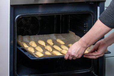Fırınlanmamış et köfteleri tepsisi Parşömen Çizgili Fırın Çarşafı 'na yerleştiriliyor.