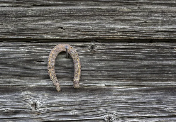 Velha ferradura enferrujada pendurada na parede — Fotografia de Stock