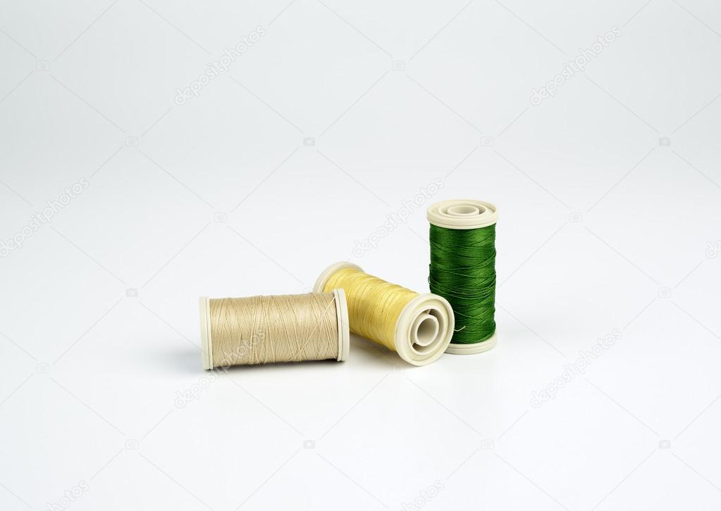colored thread spools on a white background