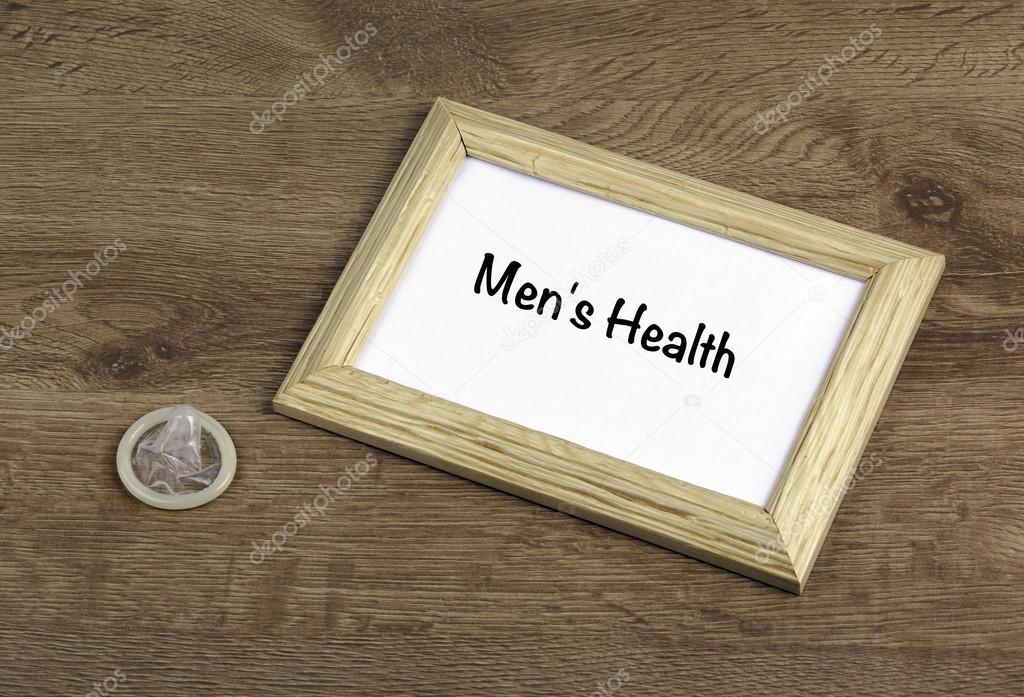 Condom on the table, wooden frame with text: Men's Health