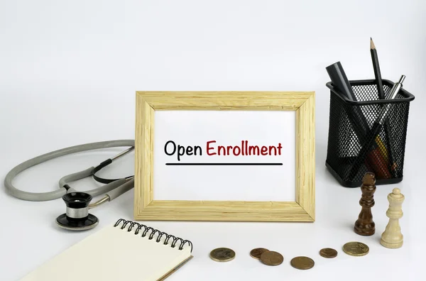 Doctor's working table with the frame and the text - Open Enroll — Stock Photo, Image