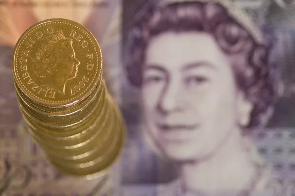 Пачка фунтовых монет на банкноте — стоковое фото