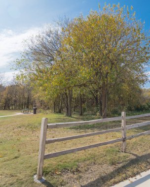 Kırsal ahşap çitli manzaralı park girişi ve renkli yapraklı patika Plano, Teksas