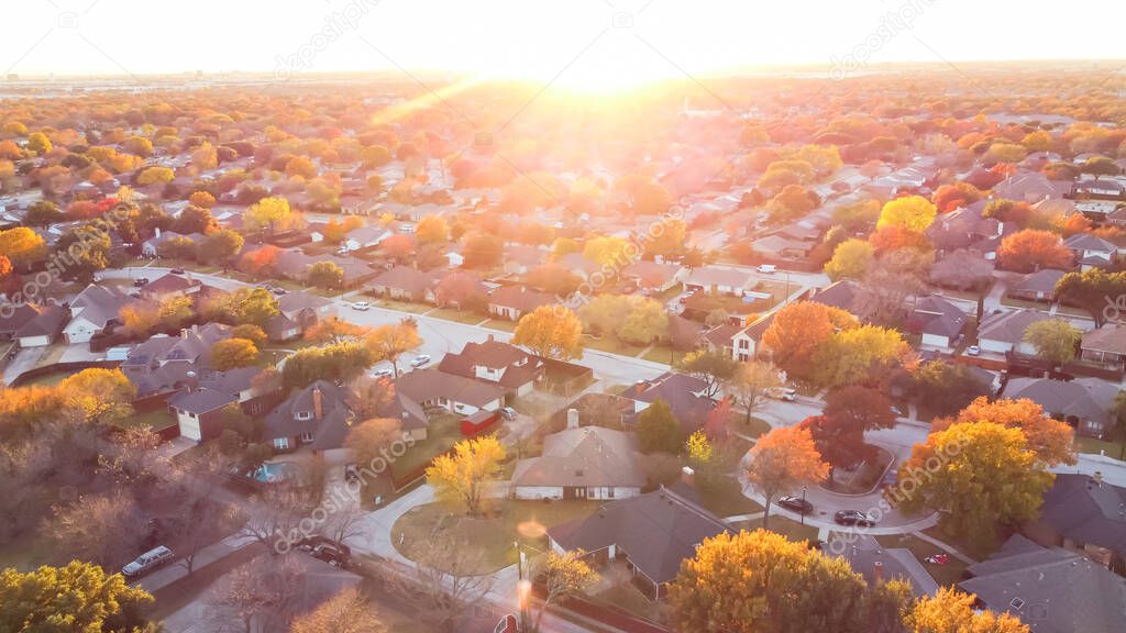 Aerial view residential neighborhood with colorful fall foliage at sunset near Dallas, Texas, America. Top view sprawl subdivision in a master planned community into horizontal line