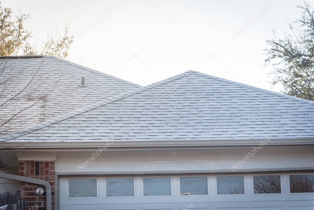 Icy roof shingles in early winter morning at suburban residential house in Coppell, Texas, USA