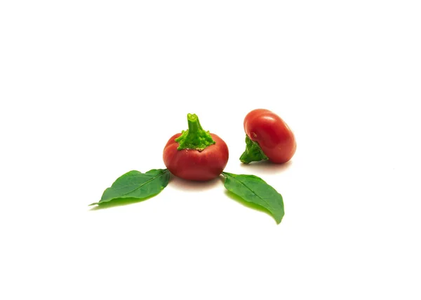 Two hot cherry peppers or pimiento fruit and fresh leaves isolated on white — Stock Photo, Image