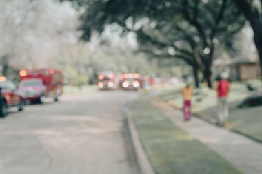 Bulanık görüntülü itfaiye araçları. Dallas, Teksas, Amerika 'nın banliyölerindeki yerleşim yerlerine ışık tutuyorlar. Komşu, kaldırımdaki yangın kazasına tanık olmuş.