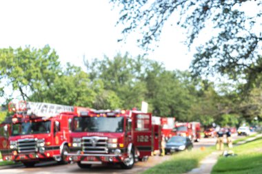 Soyut bulanık itfaiyeci yangın kurtarma kazası Dallas, Teksas, Amerika 'nın banliyölerindeki bir evde. Merdivenleri ve çalışan itfaiyecileri olan itfaiye kamyonu.