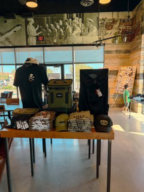 NORTH RICHLAND HILLS, TX, US-OCT 4, 25: Large historic army wall picture inside of Black Rifle Coffee Company Cafe showing branded apparel, mugs, hats, and coffee bags on display with customers. USA