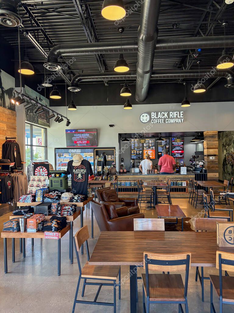 NORTH RICHLAND HILLS, TX, US-OCT 4, 25: Inside view of Black Rifle Coffee Company Cafe showing branded apparel, mugs, coffee bags, customers ordering drinks at the counter beneath industrial lighting.