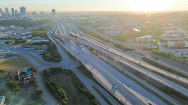 Kıvrımlı kavis kanalları Fort Worth şehir merkezindeki ufuk çizgisine trafiği, ön planda lojistik merkez, düz çatı depoları ve erken ışık ve ağaç tamponları tarafından çerçevelenmiş yön rampaları var. ABD