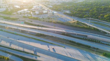 Fort Worth şehir merkezinin yakınındaki modern kavşakta köprü altında trafiğe izin veriyor, verimli ağaç tepe örtüleri, yön rampaları, atardamar yolu üzerinden ufuk çizgisi girişi, Texas. ABD