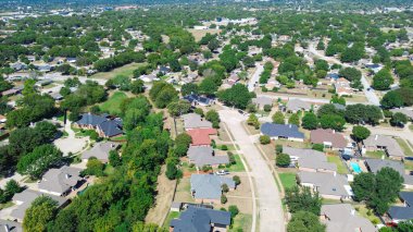Kuzey Richland Hills, Teksas 'ta büyük planlı bir topluluk lüks banliyö evleri, arka bahçe havuzları, güneş panelleri ve eğimli sokaklar boyunca dizilmiş olgun ağaçlar ve peyzaj alanları gösteriyor. ABD