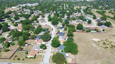 Subdivision with oversized lots in North Richland Hills, Texas showing large vacant land beside tree-lined residential, mature landscaping, school district background, ideal for future expansion. USA